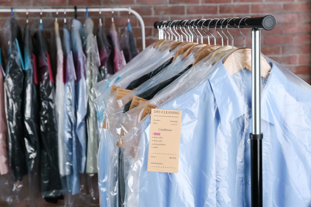 Freshly dry cleaned shirts and garments hanging on a rack